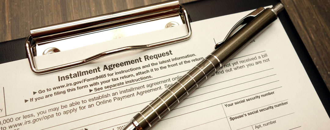 IRS installment agreement request form with pen on clipboard.