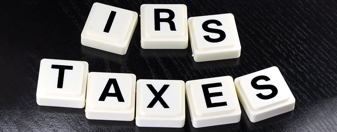 Scrabble tiles spelling out IRS and TAXES, representing tax debt and the Currently Not Collectible status.